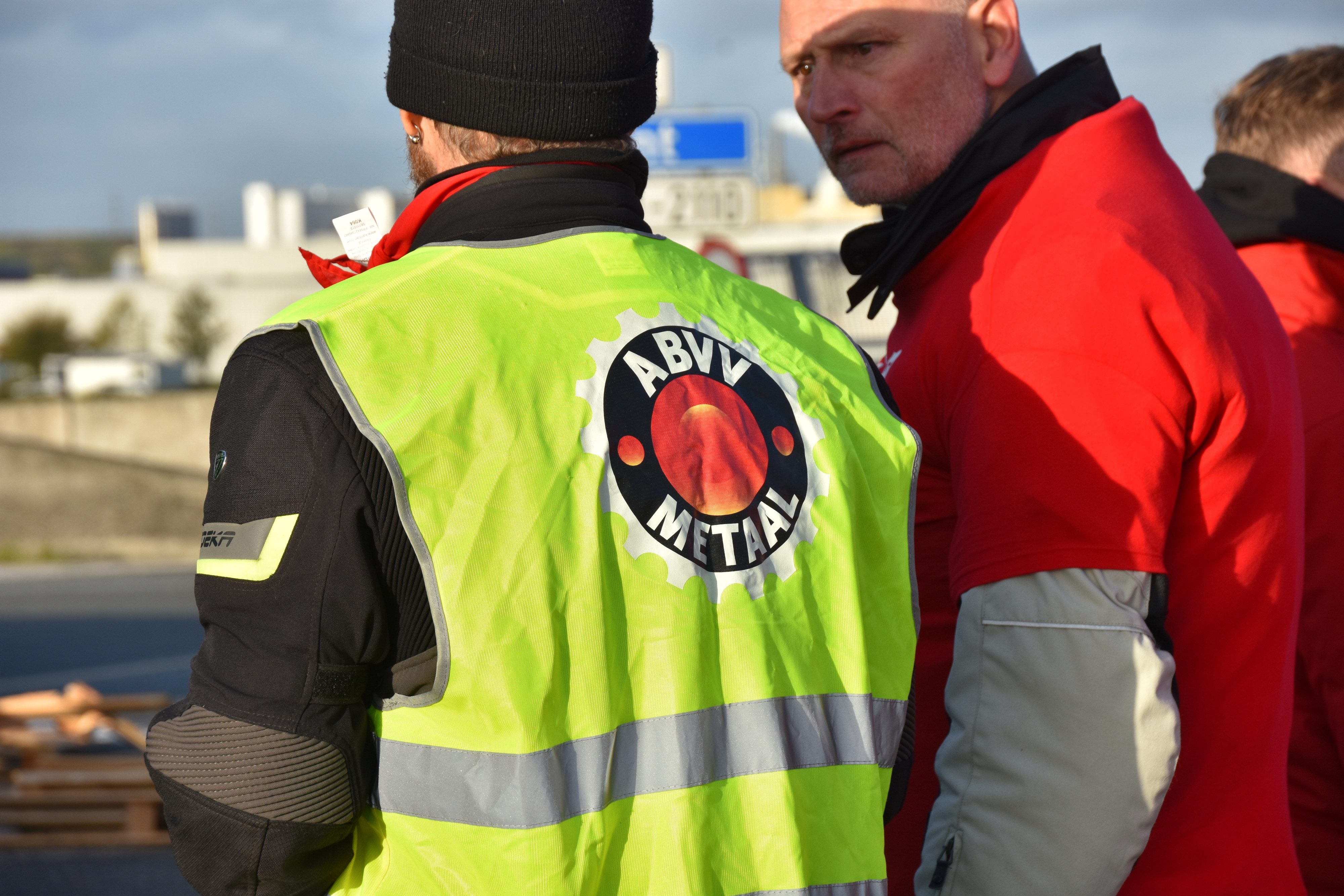 twee vakbondsdelegees in gesprek langs achteren bekeken